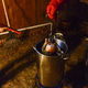 Two chefs dip a turkey into an outdoor fryer